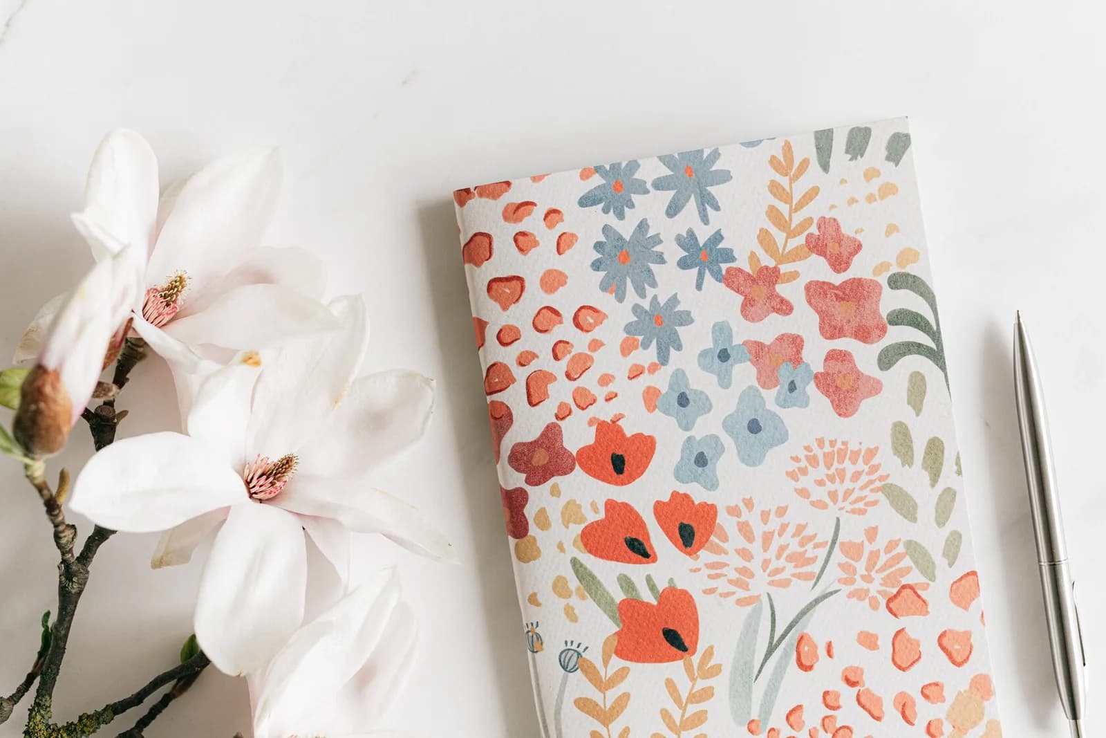 An open notebook and a cup of tea on a table